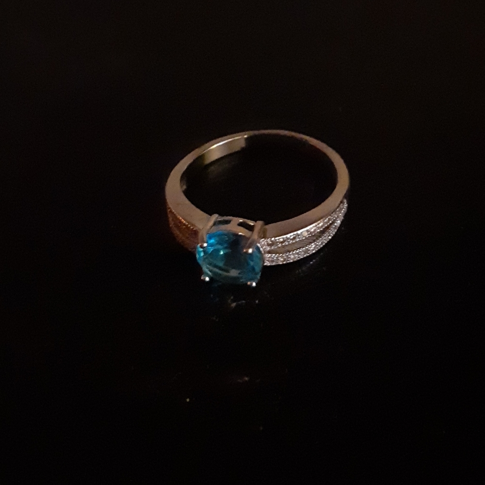 Silver toned ring with bright sky blue stone